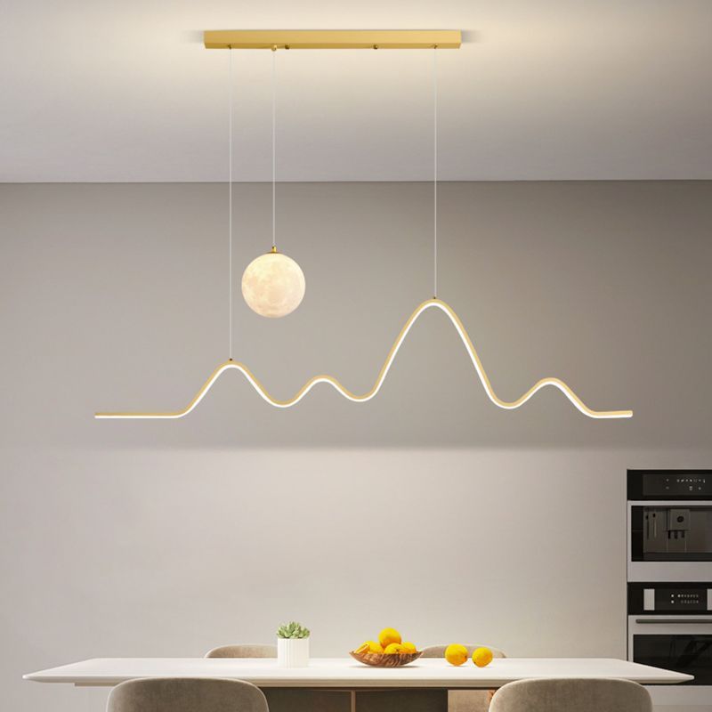 Gold Louise wavy pendant light over dining table