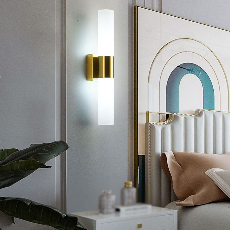 Leigh Modern Wall Lamp illuminating a bedroom with gold finish