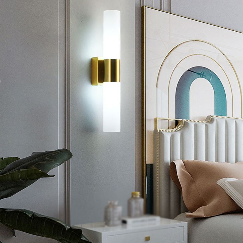 Leigh Modern Wall Lamp illuminating a bedroom with gold finish
