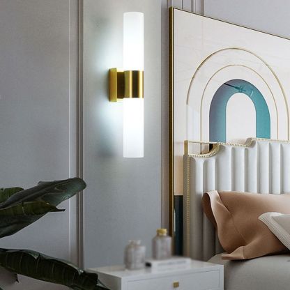 Leigh Modern Wall Lamp illuminating a bedroom with gold finish