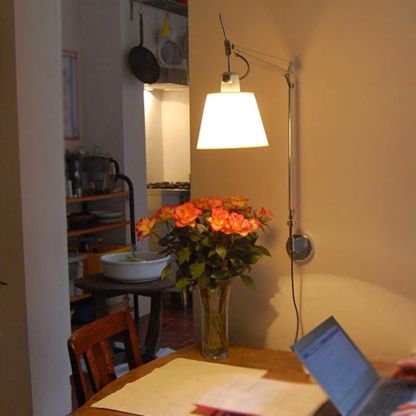 Brady wall lamp illuminating living room workspace.