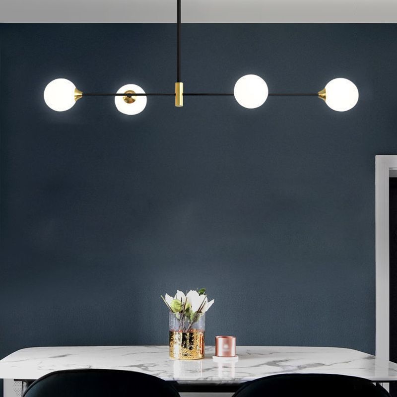 Modern black and gold pendant light above dining table