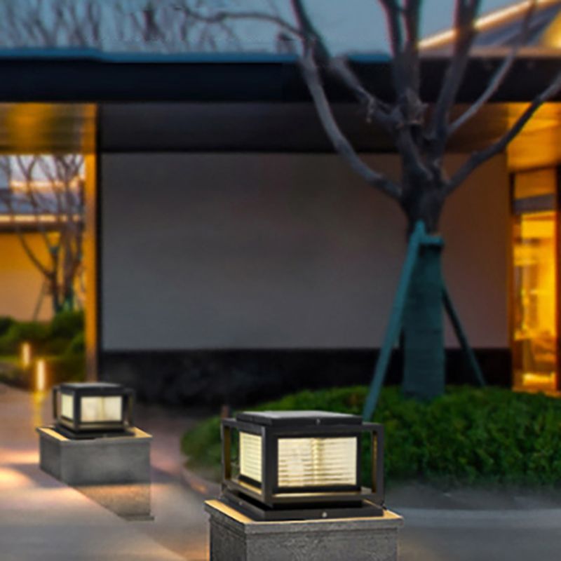 Riley black cube outdoor pillar lamps illuminating a garden at night