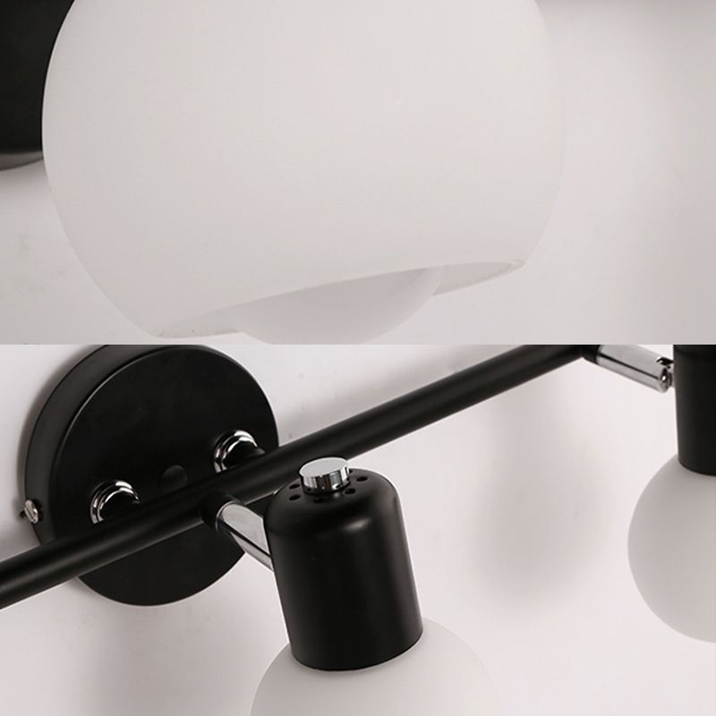 Valentina vanity wall lamp, black metal fixture and white spherical glass shades.