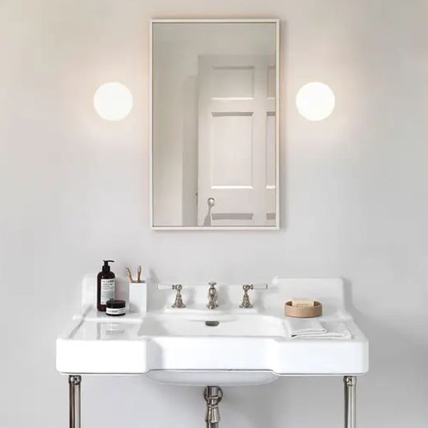 Modern bathroom with Valentina Globe Wall Lamp illuminating the mirror