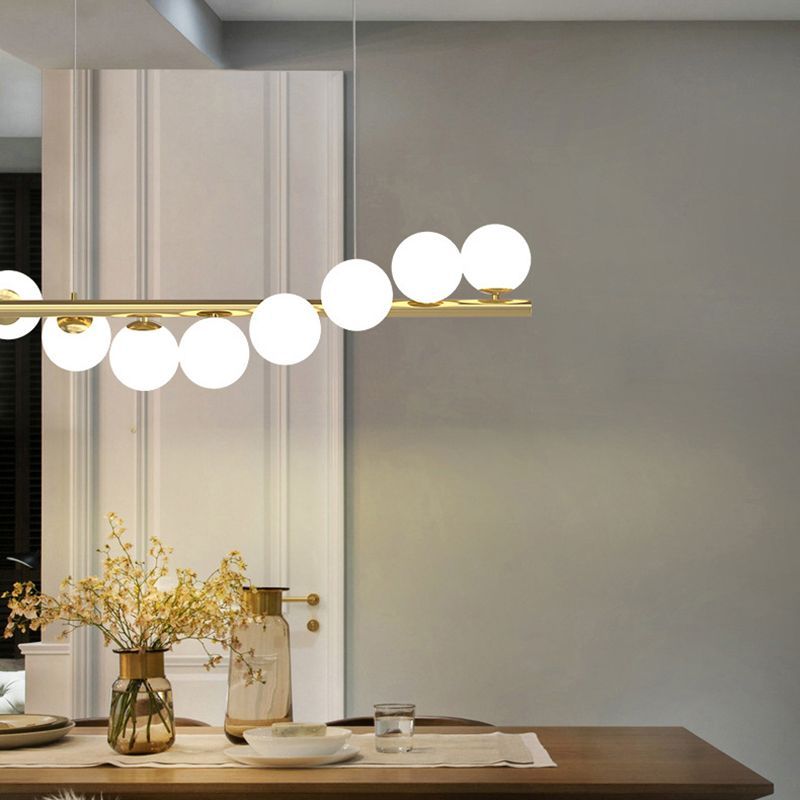 Valentina Nordic Pendant Light illuminates a dining room, gold and glass design