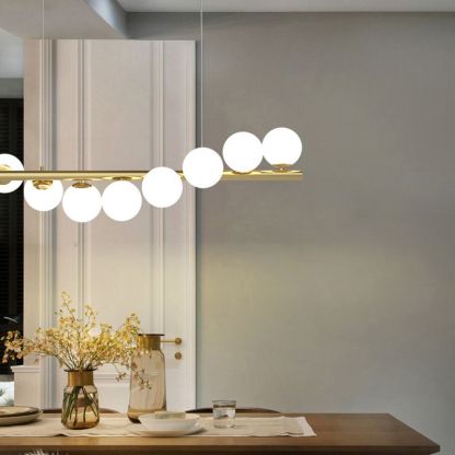 Valentina Nordic Pendant Light illuminates a dining room, gold and glass design