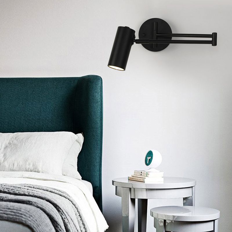 Black Freja wall lamp in modern bedroom setting.