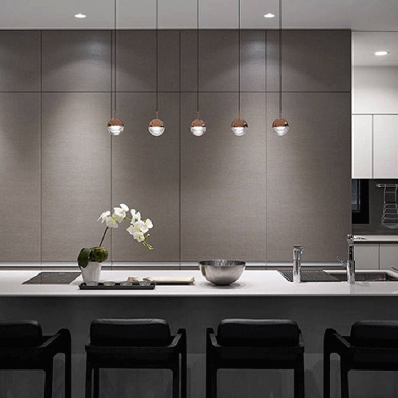 Modern kitchen with Valentina pendant lights, rose gold finish, and orchid decor.