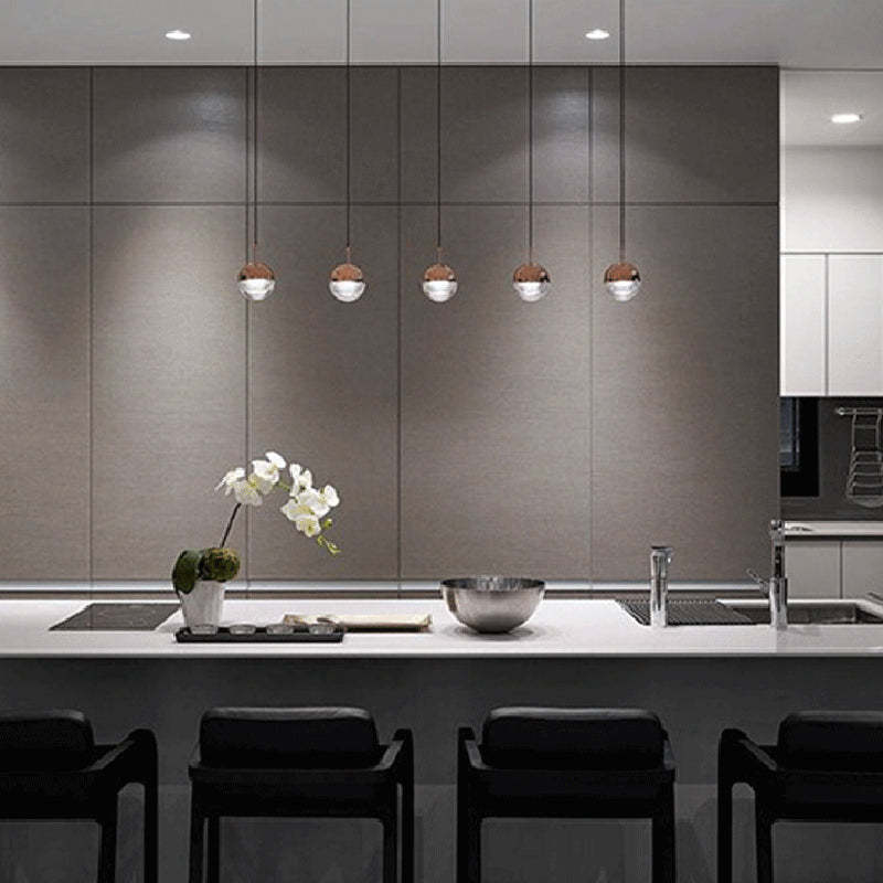 Modern kitchen with Valentina pendant lights, rose gold finish, and orchid decor.