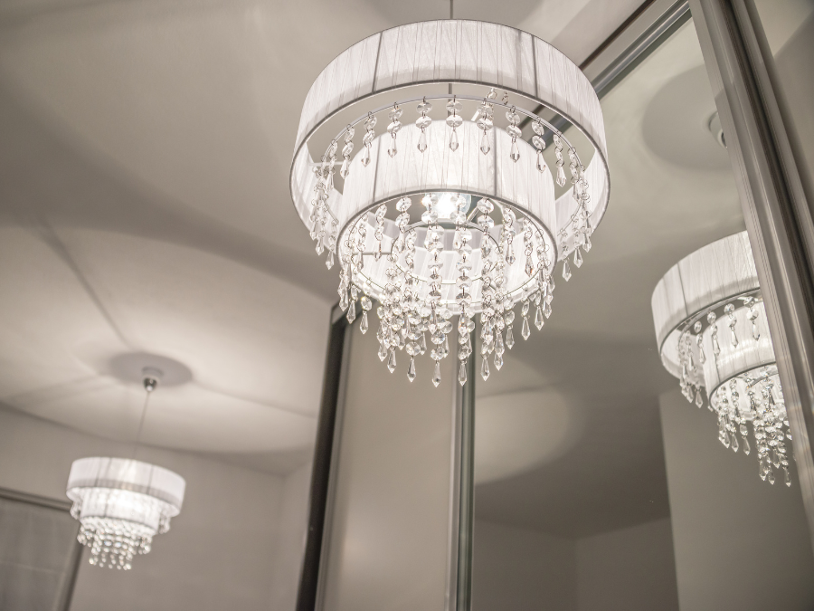 Close-up of a contemporary crystal chandelier reflecting on a mirror.