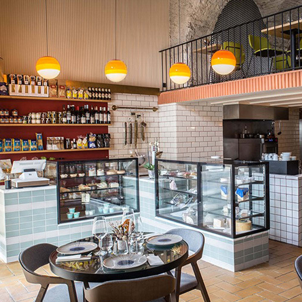 Orange Hailie glass bubble pendant lights in cafe.