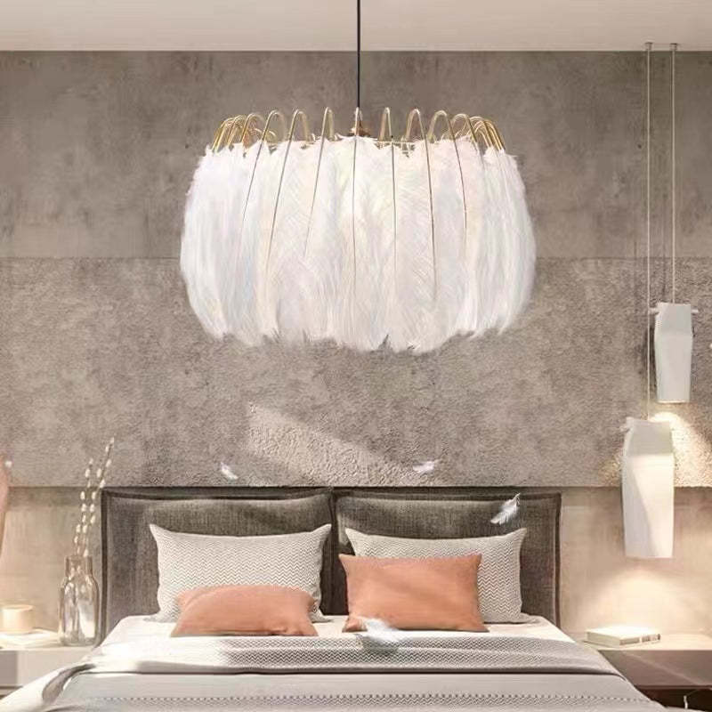 White feather pendant light over a bed in a bedroom