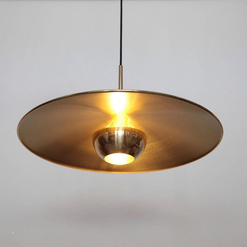 Minimalist gold pendant light with a flying saucer shape