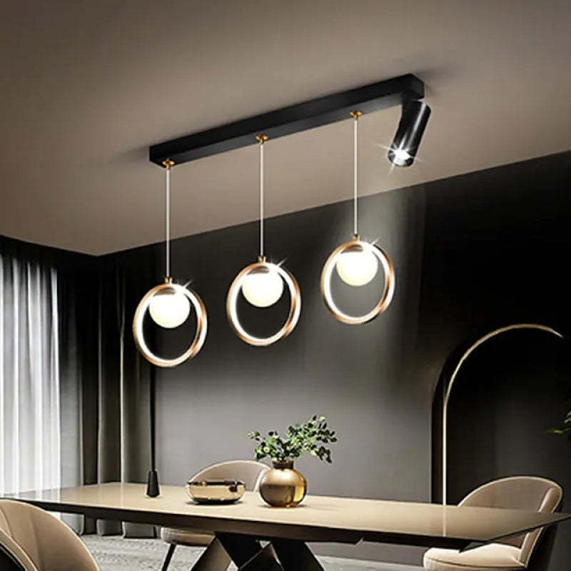 Modern pendant light over dining table, featuring metal rings and a spotlight