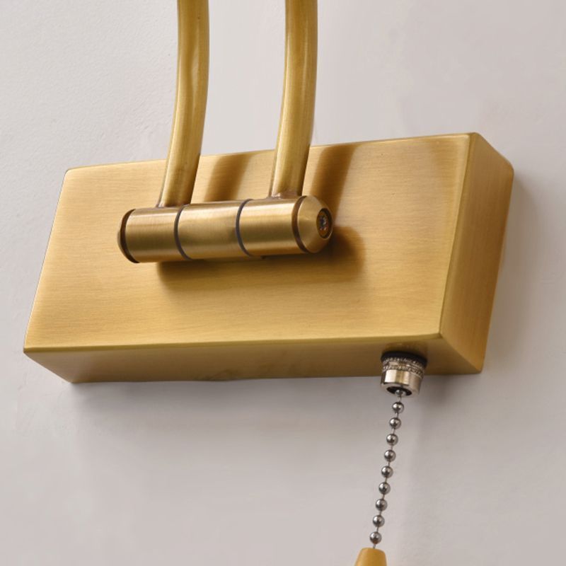 Close up of gold metal Leigh vanity wall lamp with pull chain.