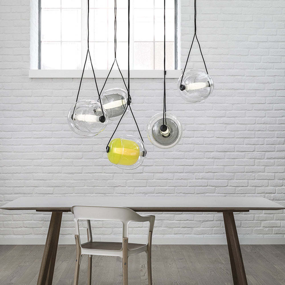 Modern bubble glass pendant lights above dining table.