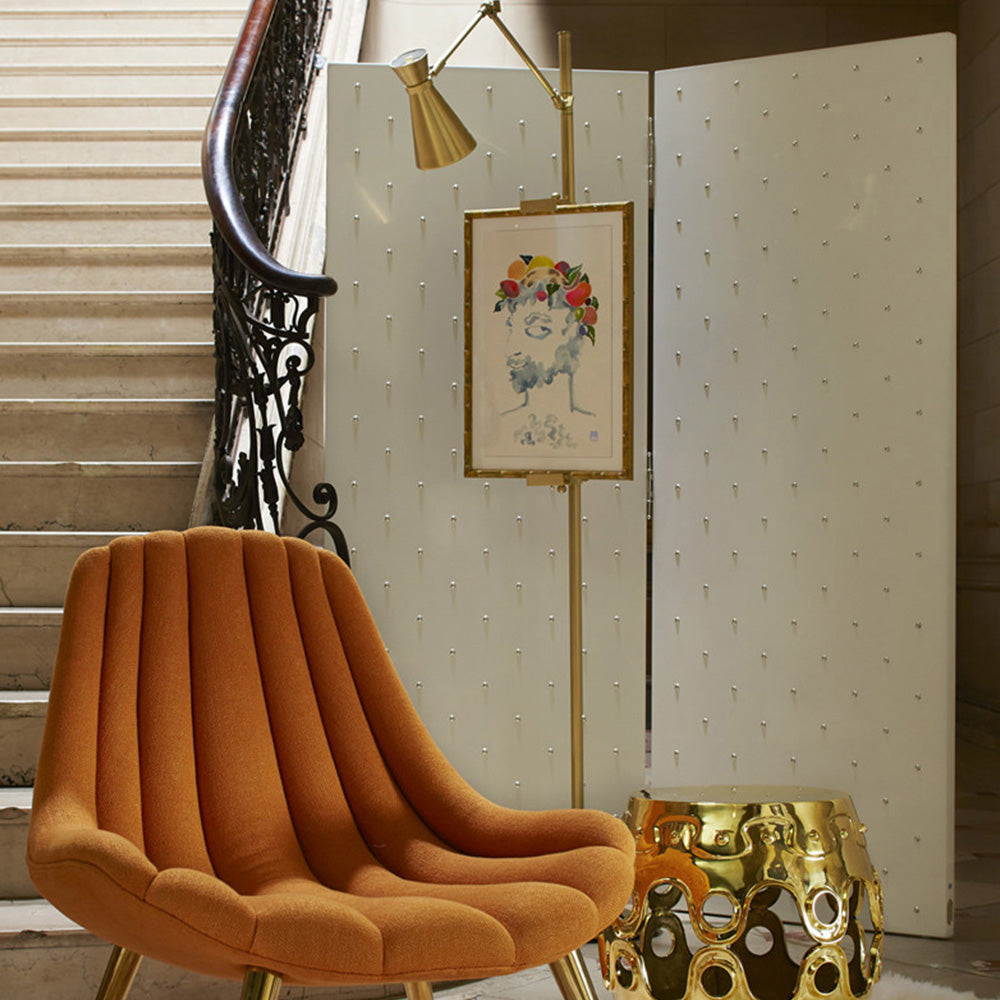 Art-deco floor lamp with painting, brass furniture, and orange chair