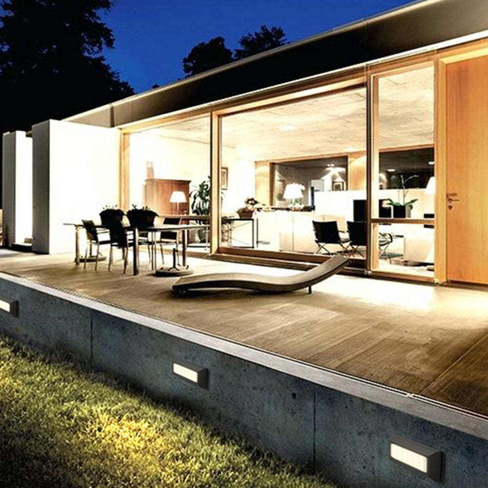 Outdoor space with Orr Rectangular Step Lights illuminating a modern home at night