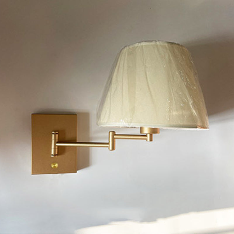 Brady gold wall lamp with fabric shade.
