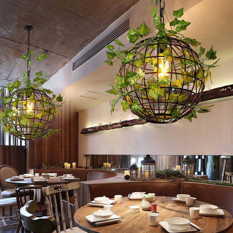Rustic globe pendant light with vine in a dining room setting.