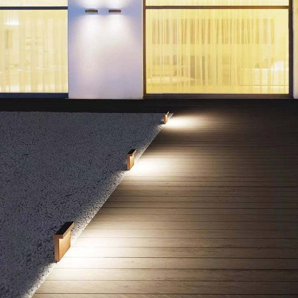 Outdoor path lights illuminate wooden walkway at night