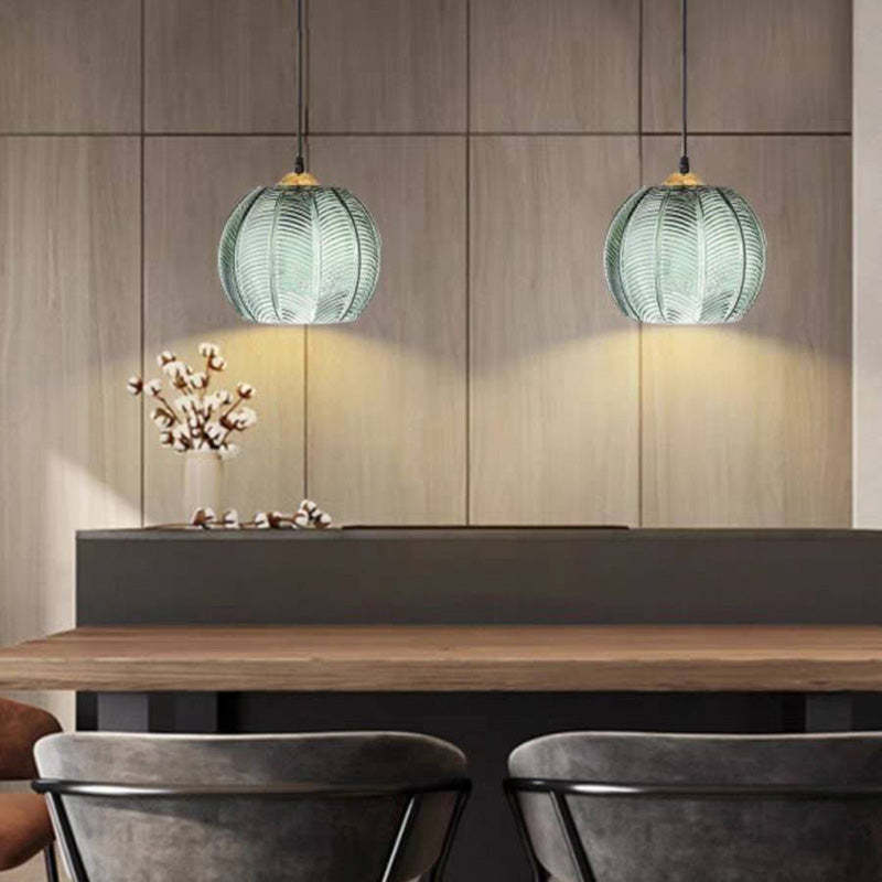 Hailie green ribbed glass pendant light over dining table.