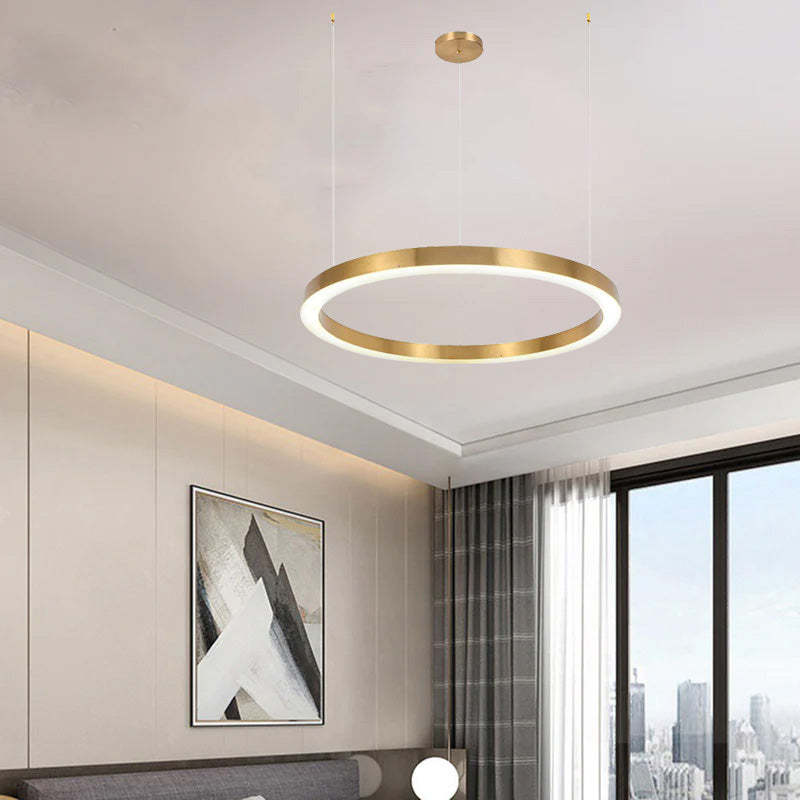 Gold ring pendant light in modern bedroom. Arisha lighting fixture.