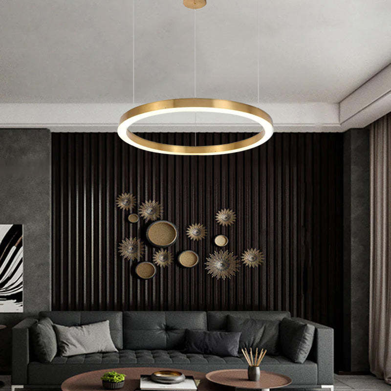 Modern Arisha gold ring pendant light over a living room sofa.