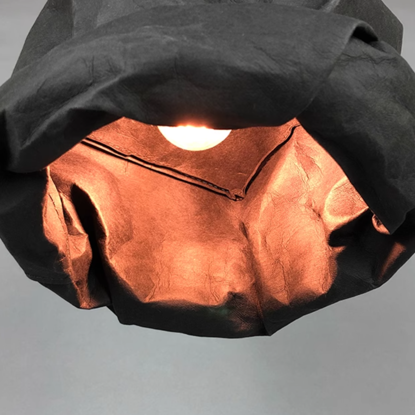 Hailie Vintage Pendant Light glowing bulb, paper shade detail