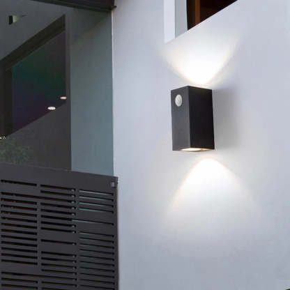 Las Sola Orr square outdoor wall lamp illuminating white wall.