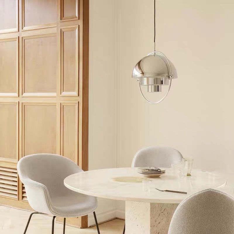 Modern silver pendant light over round dining table