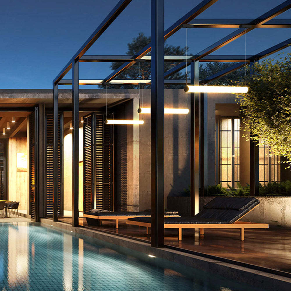 Modern cylinder pendant lights above patio lounge chairs.