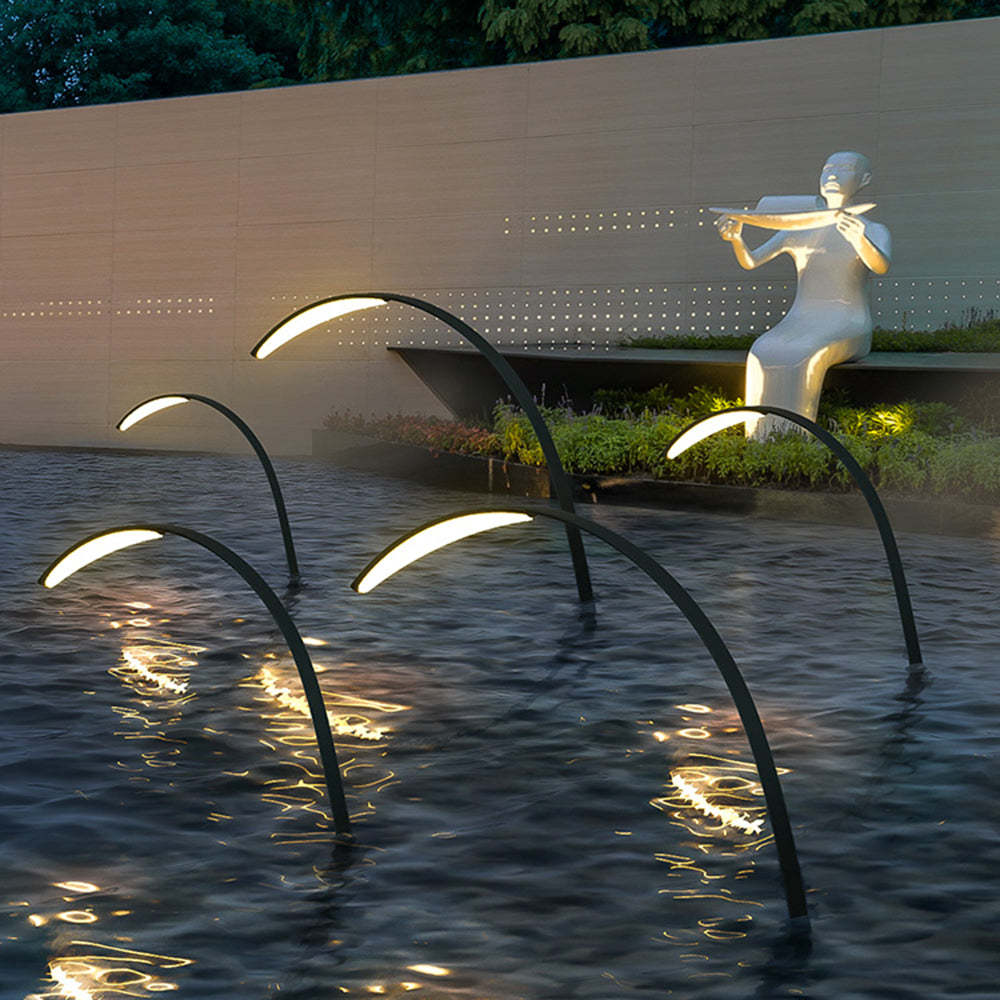 Orr Arc Poolside Ground Lamps in serene waterscape