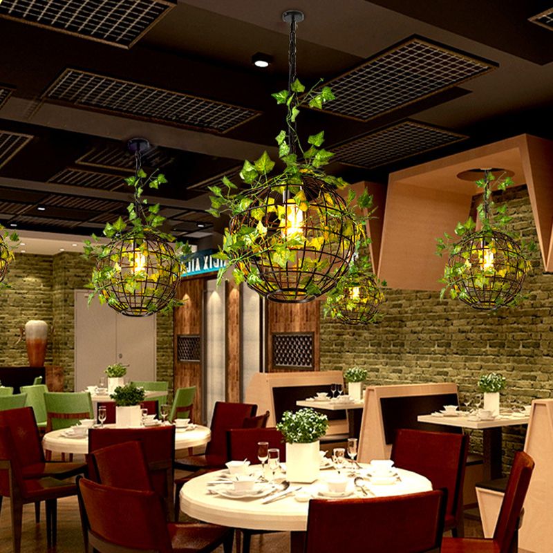 Rustic globe pendant light with vines in restaurant. Las Sola lighting.