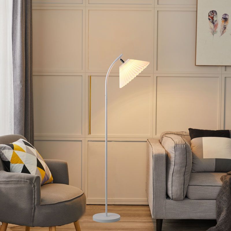 Modern floor lamp in living room setting, pleated fabric shade