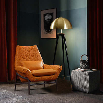 Gold shade metal tripod floor lamp in staged living room.
