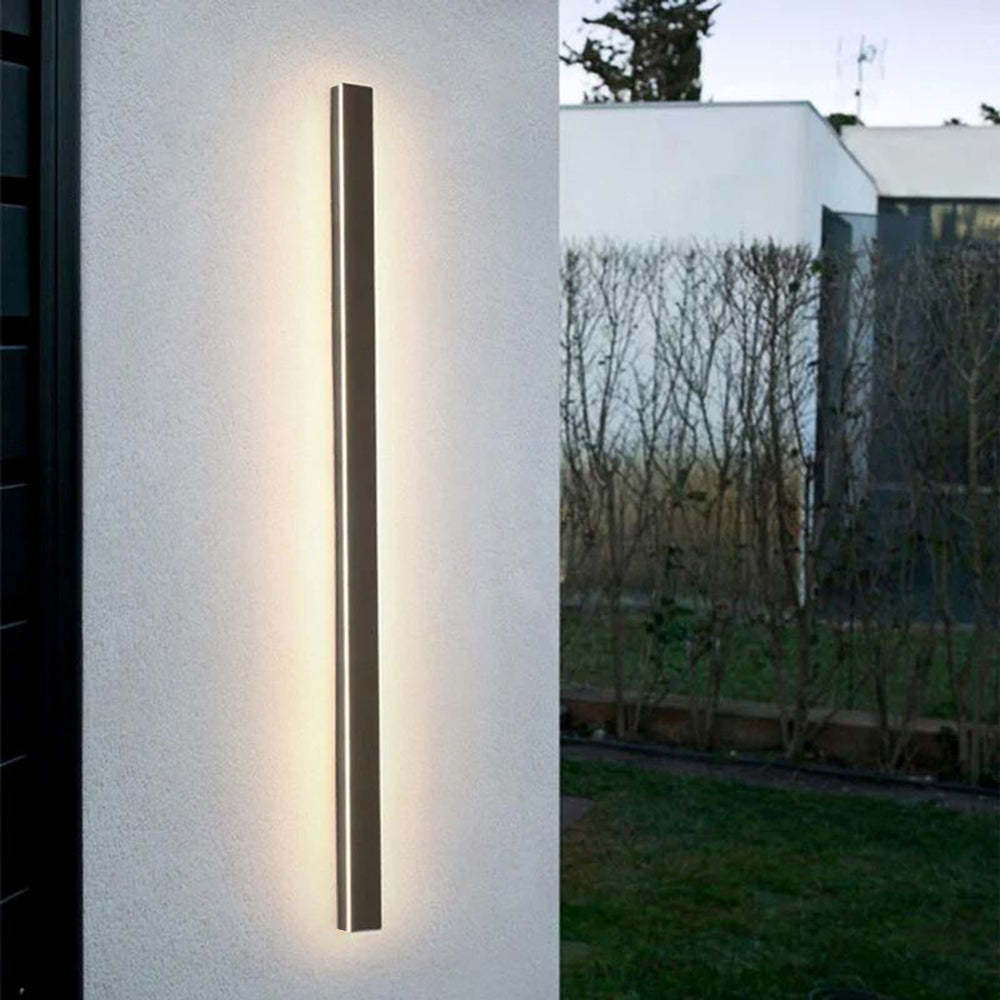 Modern minimalist outdoor wall light illuminating a home exterior