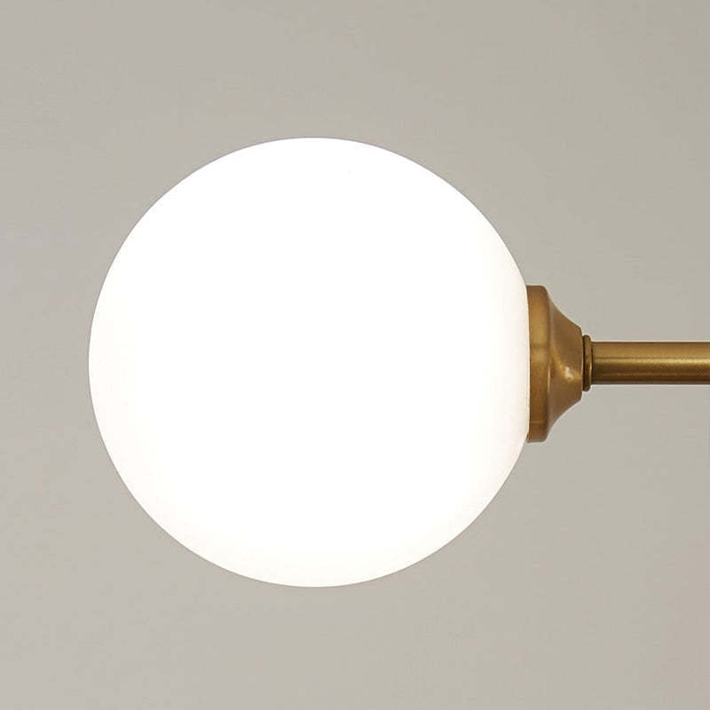 Close-up of a Valentina pendant light's illuminated globe, gold fixture