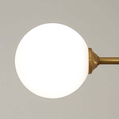 Close-up of a Valentina pendant light's illuminated globe, gold fixture