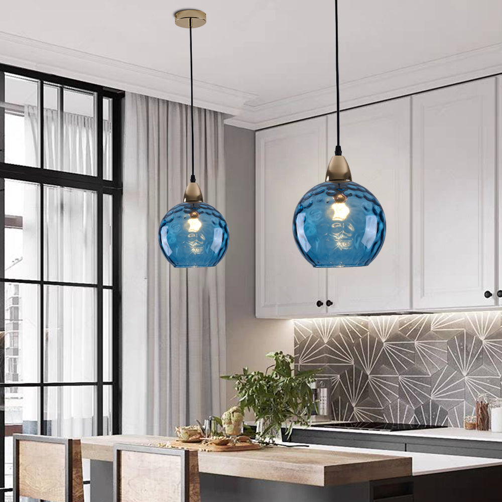 Blue glass pendant lights above kitchen island lighting.