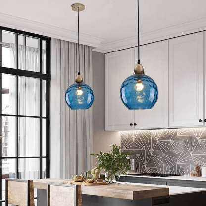 Blue glass pendant lights above kitchen island lighting.