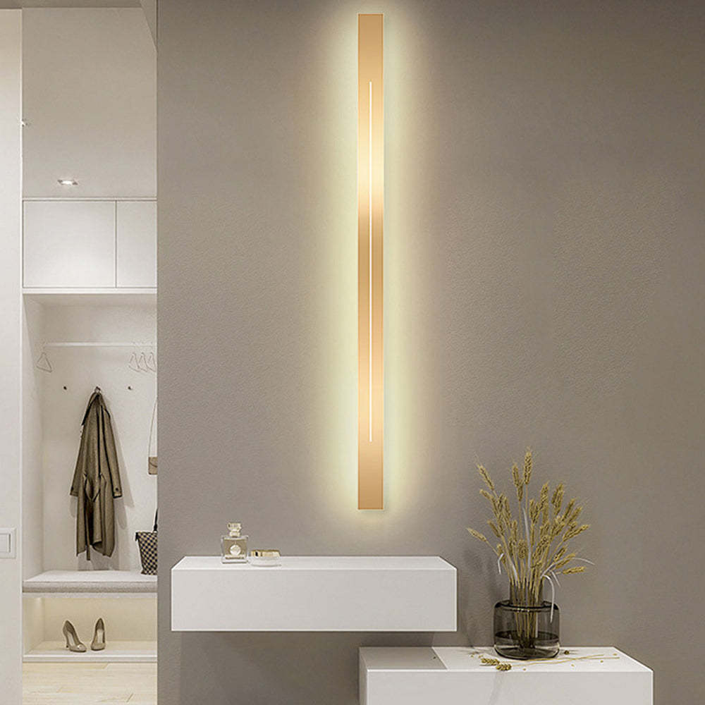 Modern gold LED wall lamp illuminating entryway, Lassola lighting