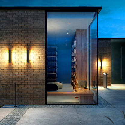 Orr Modern Outdoor Wall Lamp illuminating brick facade at dusk