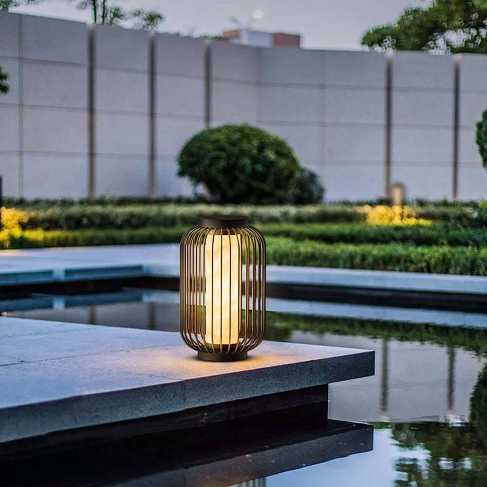 Outdoor Orr Lantern, glowing warm light on the edge of a pool