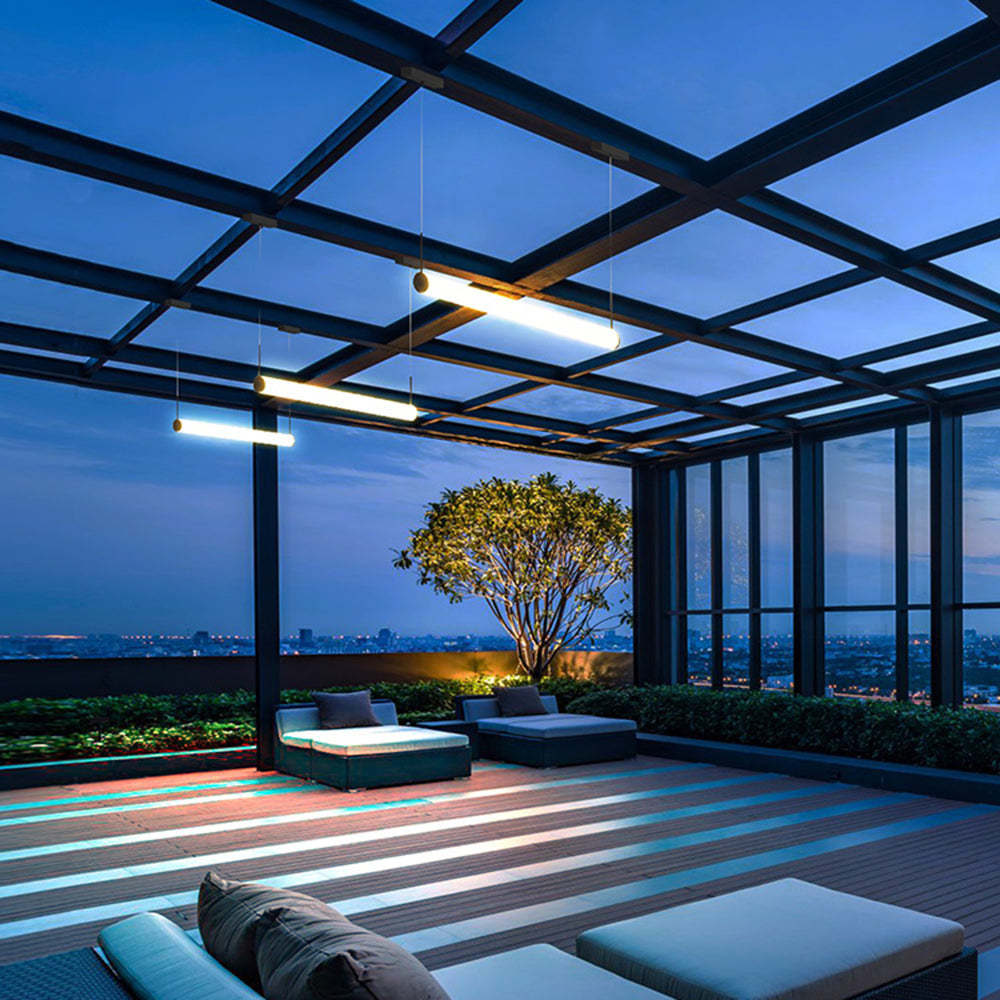 Modern cylinder pendant lights on outdoor patio at dusk.