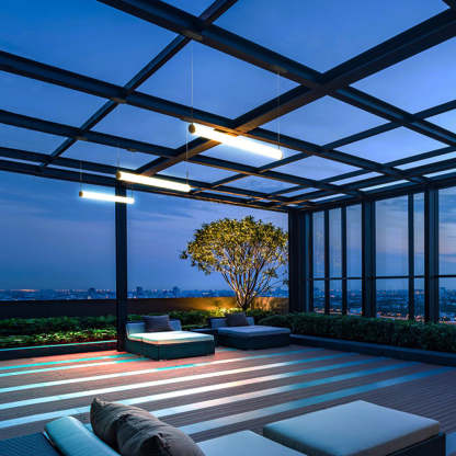Modern cylinder pendant lights on outdoor patio at dusk.