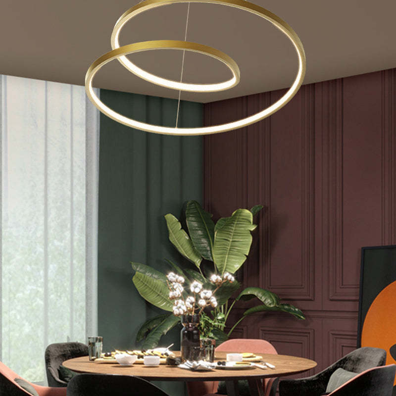 Arisha brass pendant light above round dining table.