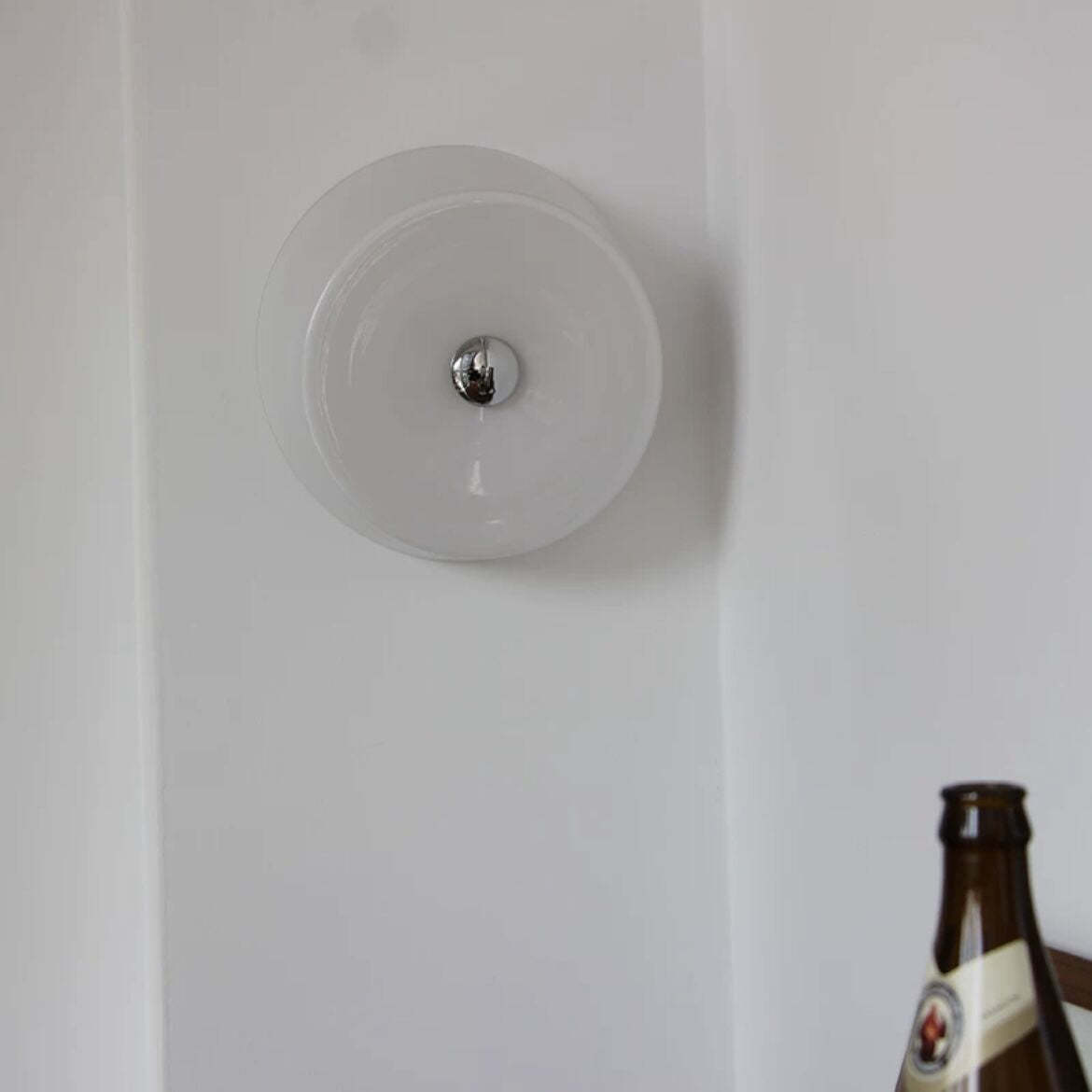 Orr Wall Light on white wall, glass and metal details.