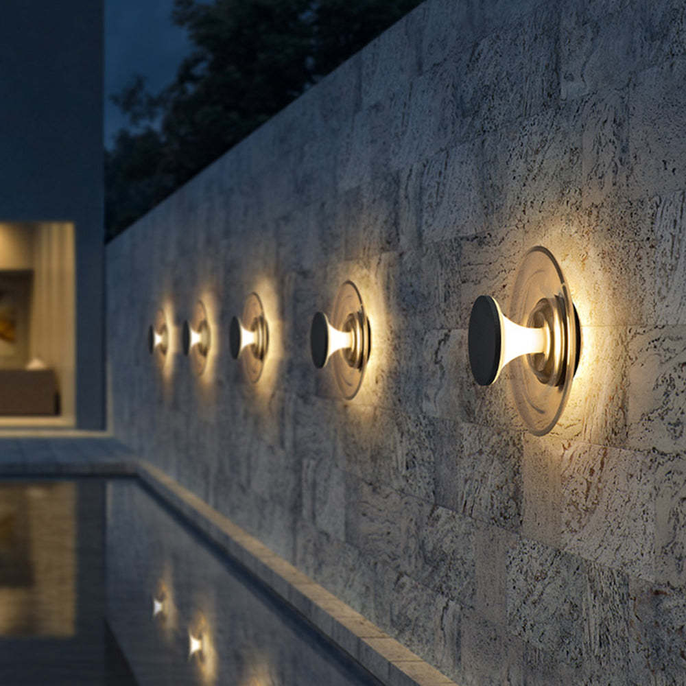 Modern wall lights illuminating a textured wall near a pool at night